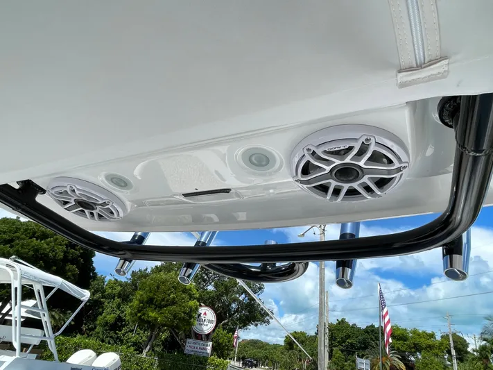 #339 White Yacht Photos Pics 2023 Everglades 273CC boat speakers and rod holders under a clear blue sky.