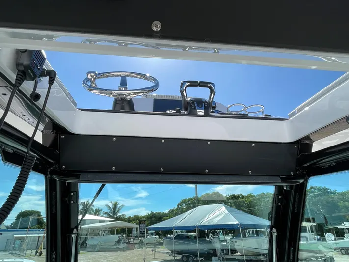 #339 White Yacht Photos Pics 2023 Everglades 273CC boat helm view with clear sky and marina background.