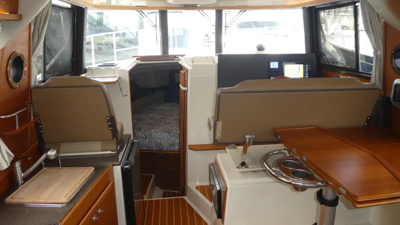 Second Act Yacht Photos Pics 2021 Ranger Tugs R-29 S interior with kitchen, seating, and navigation area.
