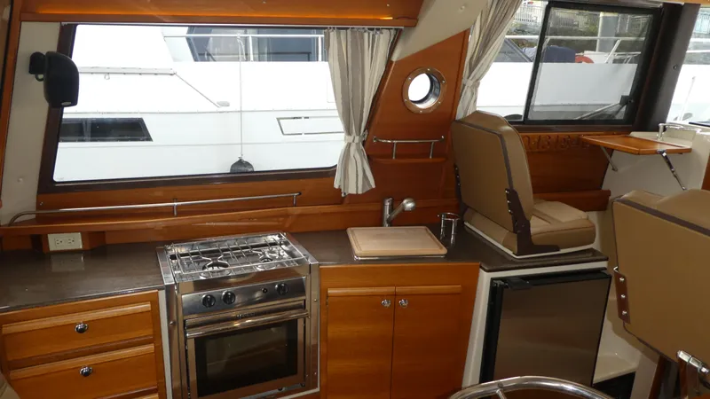 Second Act Yacht Photos Pics 2021 Ranger Tugs R-29 S interior with kitchen, stove, and seating area.