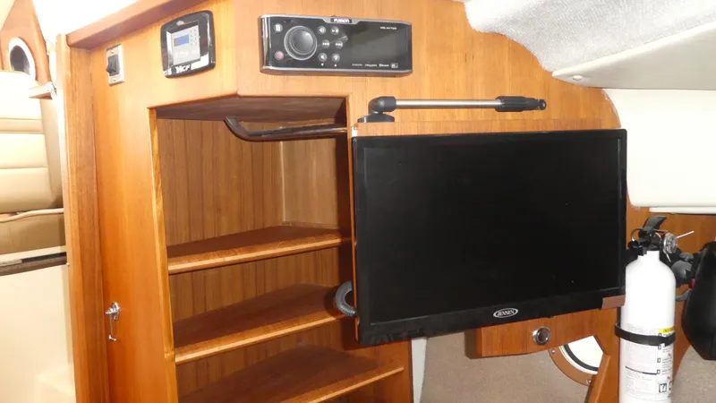 Second Act Yacht Photos Pics 2021 Ranger Tugs R-29 S interior with wooden shelves, TV, and fire extinguisher.