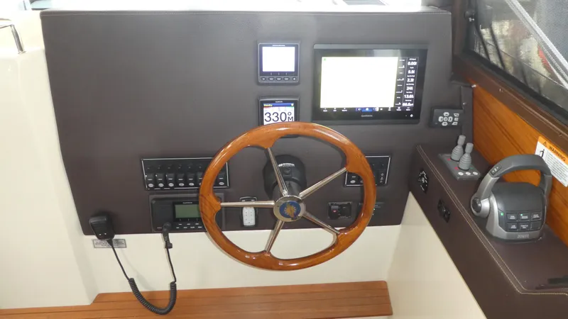 Second Act Yacht Photos Pics Helm of 2021 Ranger Tugs R-29 S with wooden steering wheel and navigation controls.