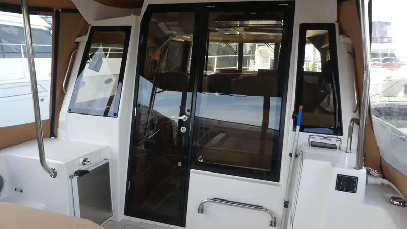 Second Act Yacht Photos Pics 2021 Ranger Tugs R-29 S boat interior with glass door and seating area.
