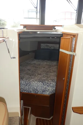 Second Act Yacht Photos Pics 2021 Ranger Tugs R-29 S cabin interior with bed and wooden accents.