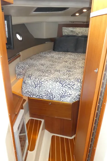 Second Act Yacht Photos Pics 2021 Ranger Tugs R-29 S cabin interior with cozy bed and wooden accents.
