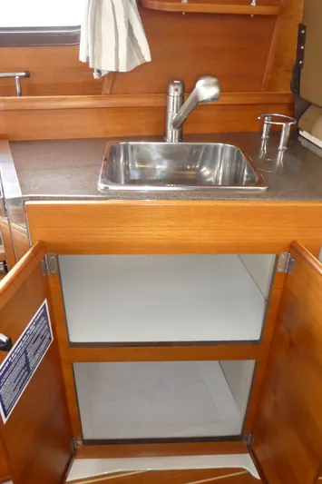 Second Act Yacht Photos Pics 2021 Ranger Tugs R-29 S galley sink with wooden cabinetry and open storage.