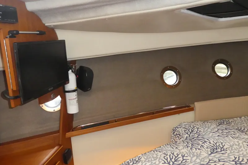 Second Act Yacht Photos Pics Interior of 2021 Ranger Tugs R-29 S with portholes, TV, and patterned bedding.