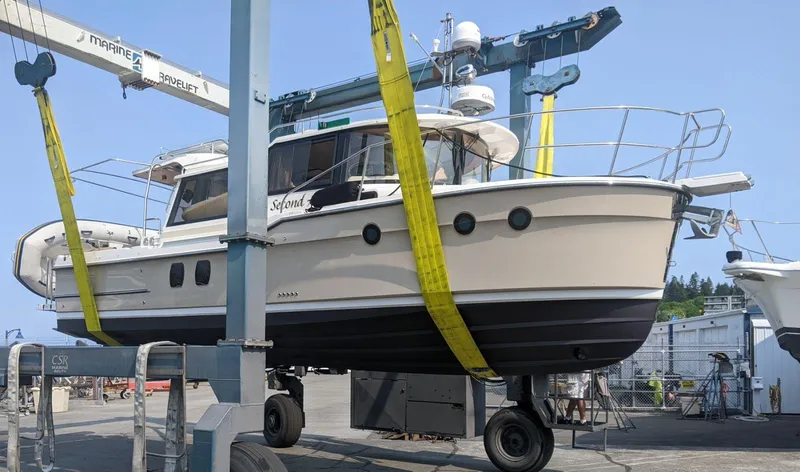 Second Act Yacht Photos Pics 2021 Ranger Tugs R-29 S boat in dry dock, supported by yellow straps.