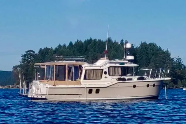 Second Act Yacht Photos Pics 2021 Ranger Tugs R-29 S boat on a serene lake with forested background.