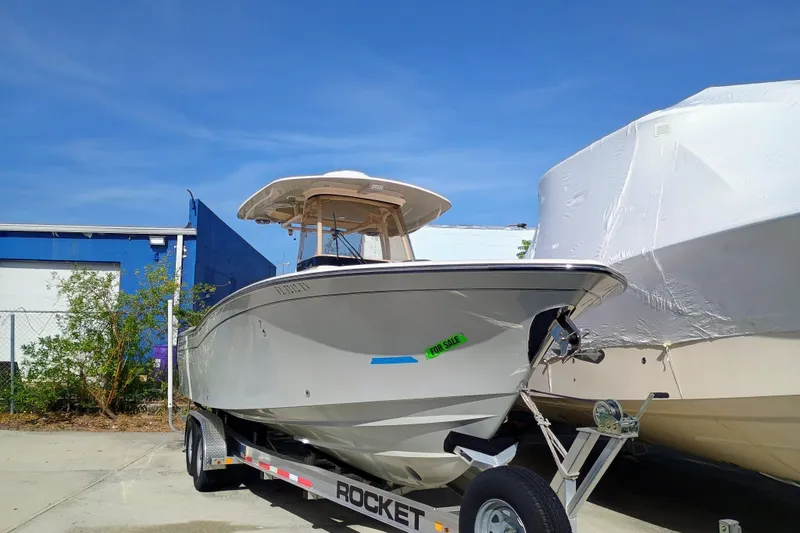 271-508 Brokerage Joe Yacht Photos Pics 2023 Grady-White Canyon 271 boat on trailer, for sale, under clear blue sky.