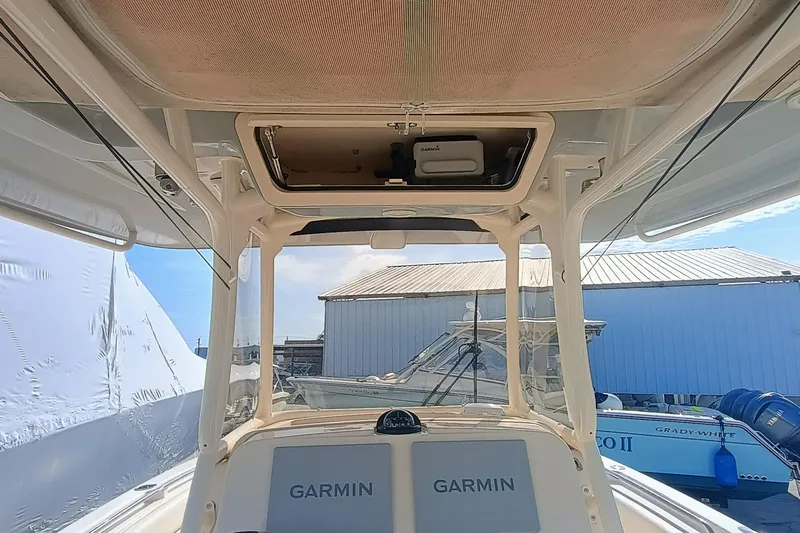 271-508 Brokerage Joe Yacht Photos Pics 2023 Grady-White Canyon 271 boat interior with Garmin electronics, docked near other boats.