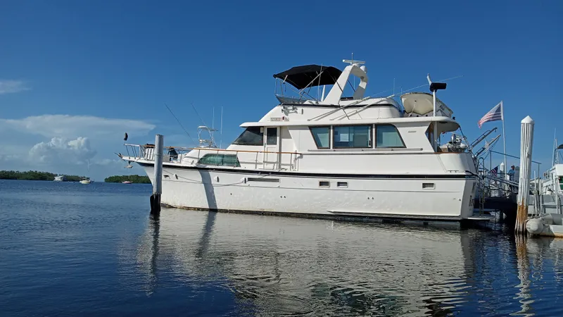 Revanche II Yacht Photos Pics 1986 Hatteras 53 Extended Deckhouse Motor Yacht docked on calm water.
