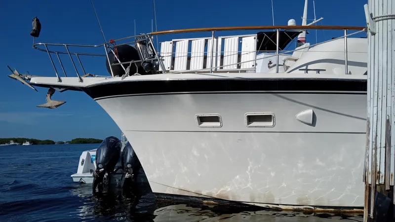Revanche II Yacht Photos Pics 1986 Hatteras 53 Extended Deckhouse Motor Yacht docked on calm water.
