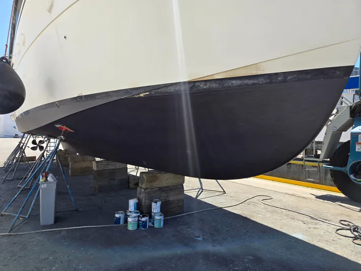 Revanche II Yacht Photos Pics 1986 Hatteras 53 Extended Deckhouse yacht undergoing maintenance with paint cans nearby.