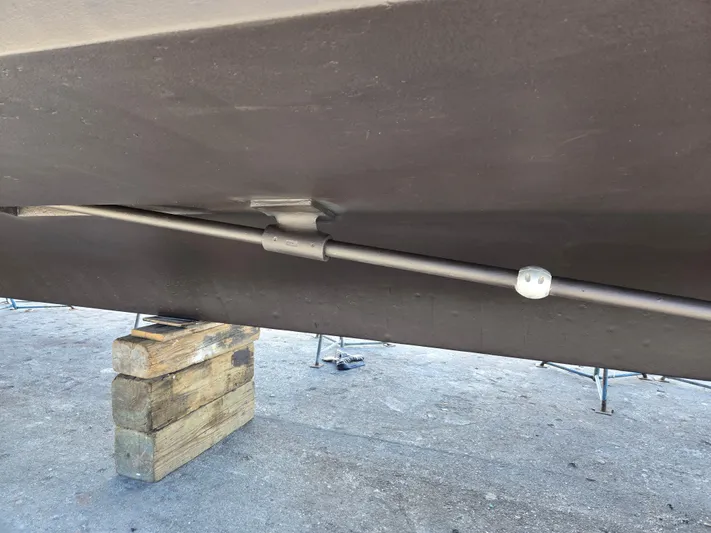 Revanche II Yacht Photos Pics Bottom view of a 1986 Hatteras 53 Extended Deckhouse on blocks, showing hull and propeller shaft.