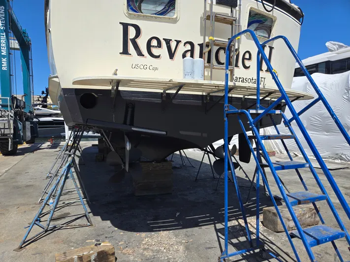 Revanche II Yacht Photos Pics 1986 Hatteras 53 Extended Deckhouse yacht on dry dock with blue ladder and support stands.