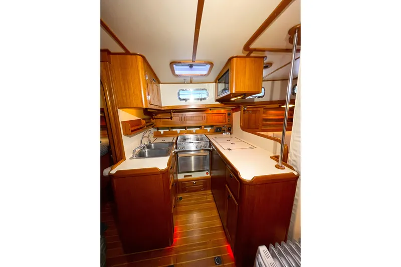 Skimmer Yacht Photos Pics Interior of 2000 Valiant 42 yacht kitchen with wooden cabinetry and modern appliances.