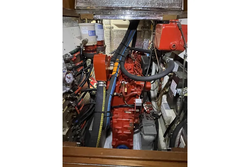 Skimmer Yacht Photos Pics Engine compartment of a 2000 Valiant 42 boat, featuring red engine and hoses.