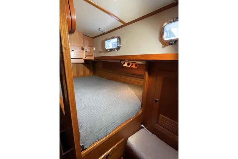 Skimmer Yacht Photos Pics Cozy cabin interior of 2000 Valiant 42 sailboat with wooden finish and portholes.