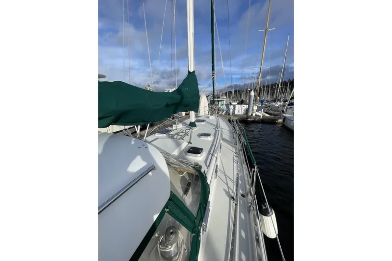 Skimmer Yacht Photos Pics Sailboat Valiant 42, 2000 model, docked at marina with green sail cover.