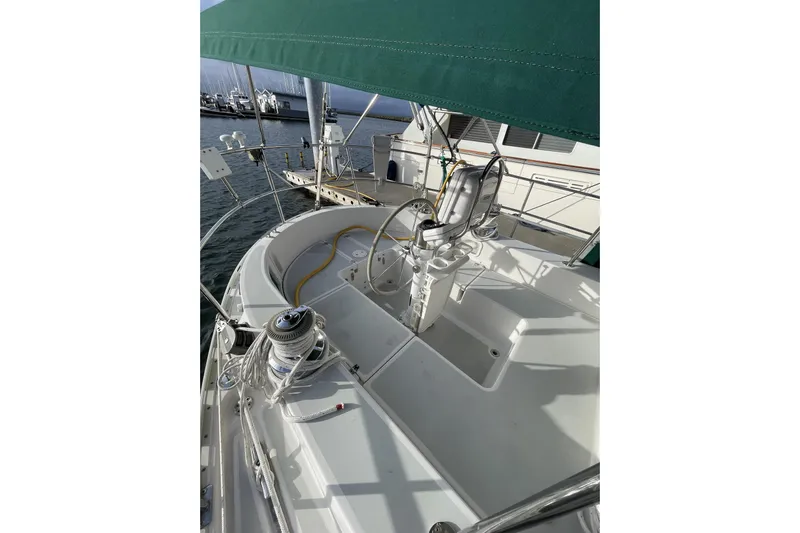 Skimmer Yacht Photos Pics Valiant 42 sailboat cockpit, 2000 model, with green canopy and marina background.