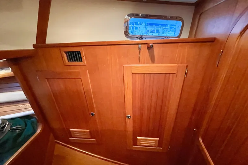 Skimmer Yacht Photos Pics Interior of 2000 Valiant 42 sailboat with wooden cabinetry and porthole window.