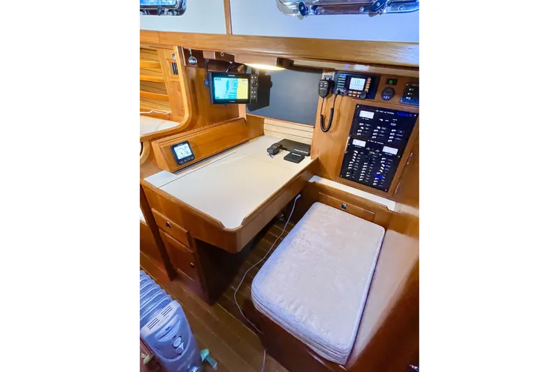 Skimmer Yacht Photos Pics Navigation station in 2000 Valiant 42 yacht with control panel and seating.
