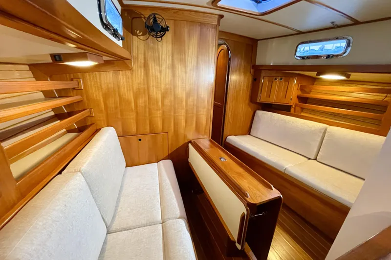 Skimmer Yacht Photos Pics Luxurious interior of 2000 Valiant 42 yacht with wooden finishes and cozy seating.