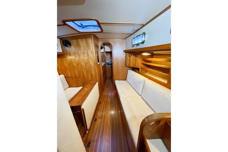 Skimmer Yacht Photos Pics Interior of 2000 Valiant 42 yacht with wooden paneling and white seating.