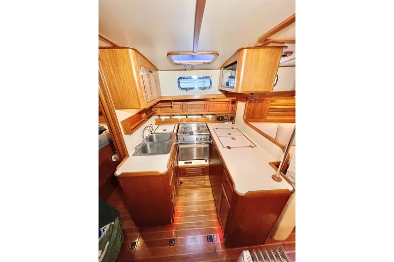 Skimmer Yacht Photos Pics Luxurious Valiant 42 yacht kitchen interior, featuring wood cabinetry and modern appliances, year 2000.
