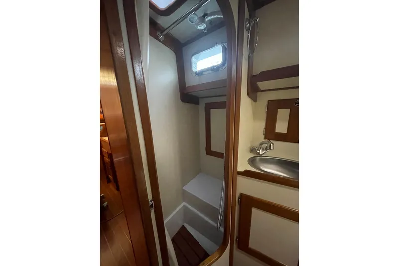 Skimmer Yacht Photos Pics Compact bathroom in 2000 Valiant 42 yacht with wooden accents and porthole window.