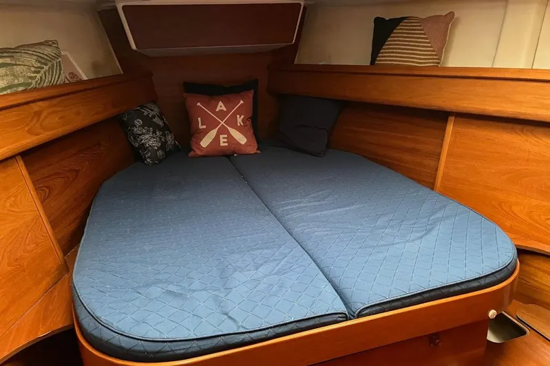Arrow Yacht Photos Pics Cozy cabin interior of 2008 Jeanneau Sun Odyssey 45 with blue bedding and decorative pillows.