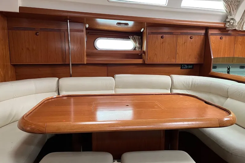 Arrow Yacht Photos Pics Luxurious interior of 2008 Jeanneau Sun Odyssey 45 yacht with wooden table and seating.