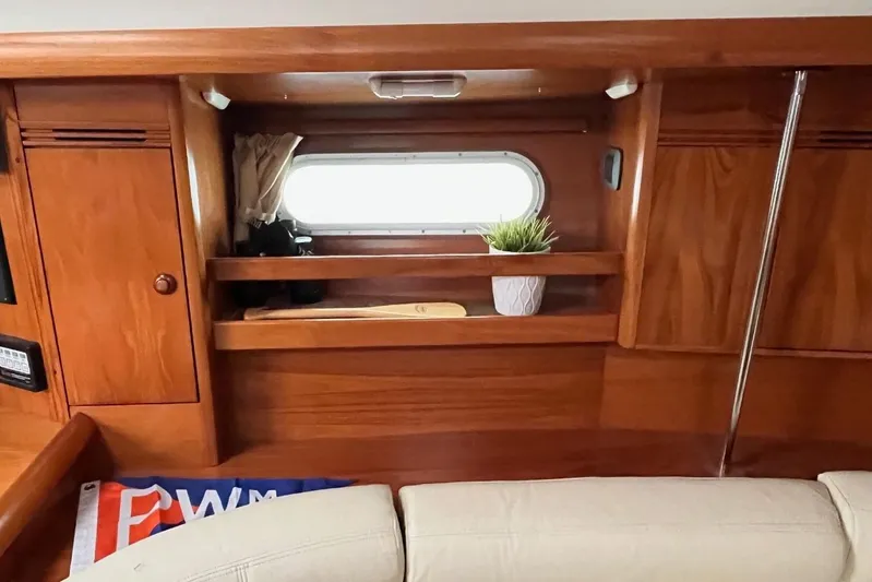 Arrow Yacht Photos Pics Interior of 2008 Jeanneau Sun Odyssey 45 yacht with wooden cabinetry and porthole.