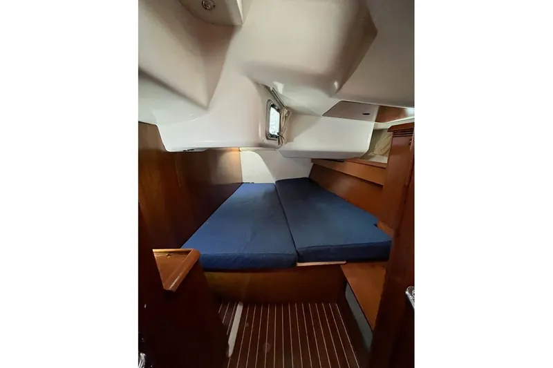 Arrow Yacht Photos Pics Interior cabin of 2008 Jeanneau Sun Odyssey 45 sailboat with blue cushions.