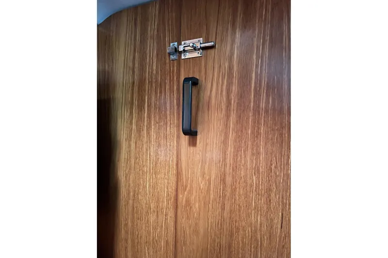 Arrow Yacht Photos Pics Wooden cabin door with black handle and latch on Jeanneau Sun Odyssey 45, 2008 model.