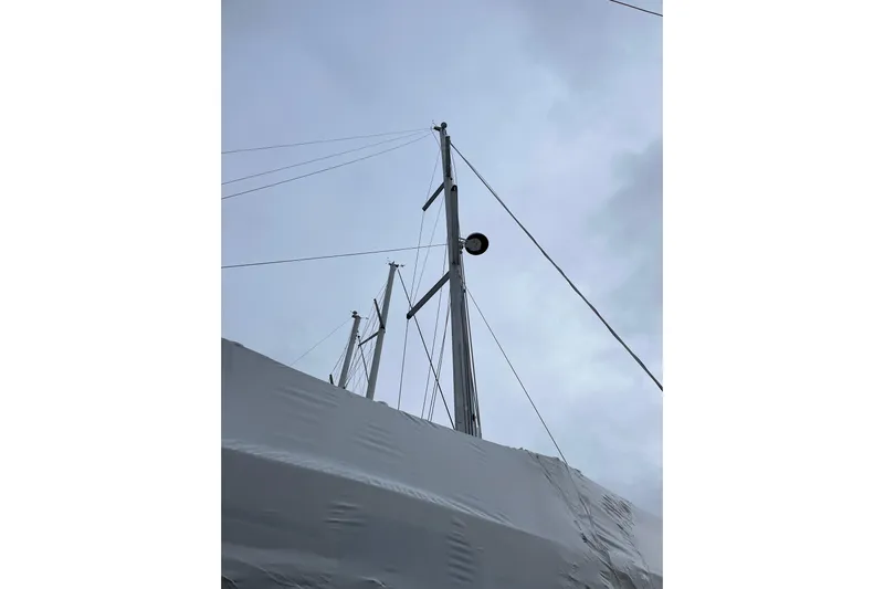 Arrow Yacht Photos Pics Masts of a 2008 Jeanneau Sun Odyssey 45 sailboat against a cloudy sky.