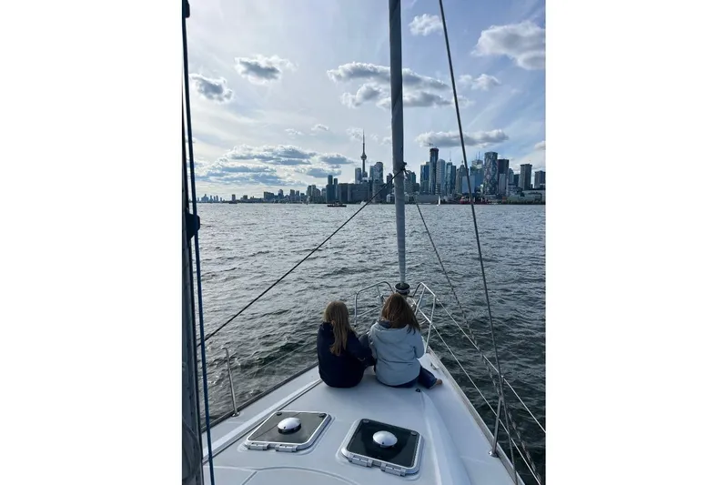 Arrow Yacht Photos Pics Two people on Jeanneau Sun Odyssey 45 sailboat, 2008, with city skyline view.
