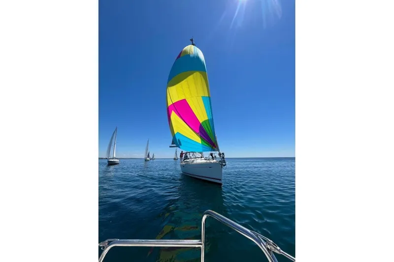 Arrow Yacht Photos Pics Jeanneau Sun Odyssey 45 sailing with colorful spinnaker on a clear day, 2008 model.