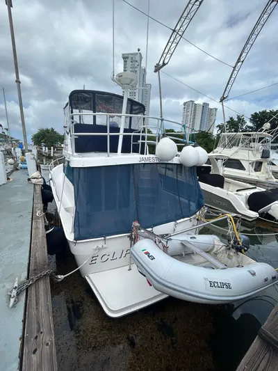  Yacht Photos Pics 1999 Mainship 350 Trawler docked with inflatable boat, marina background.
