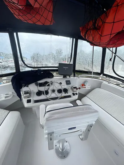  Yacht Photos Pics 1999 Mainship 350 Trawler helm with steering wheel, navigation equipment, and seating.