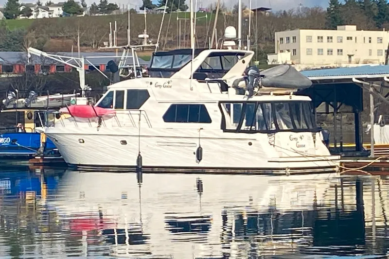 Grey Goose Yacht Photos Pics Luxury Compass 55 yacht docked at marina, reflecting on calm water, 2000 model.