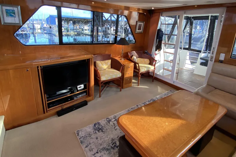 Grey Goose Yacht Photos Pics Luxurious interior of 2000 Compass 55 yacht with TV, seating, and marina view.