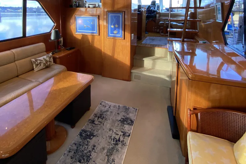 Grey Goose Yacht Photos Pics Luxurious interior of a 2000 Compass 55 yacht with elegant wood finishes and comfortable seating.