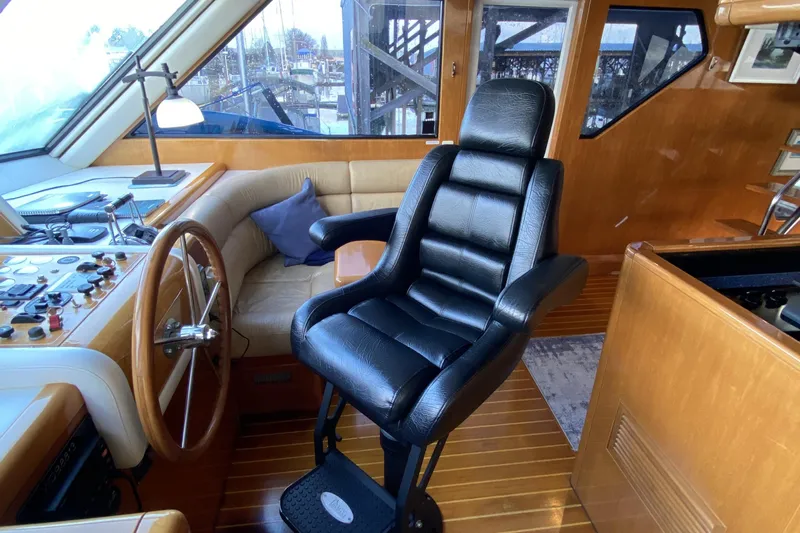 Grey Goose Yacht Photos Pics Luxurious interior of 2000 Compass 55 yacht with leather captain's chair and wooden steering wheel.