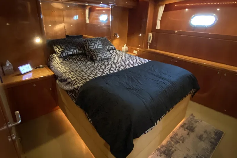 Grey Goose Yacht Photos Pics Luxurious bedroom interior of a 2000 Compass 55 yacht with elegant wood paneling.