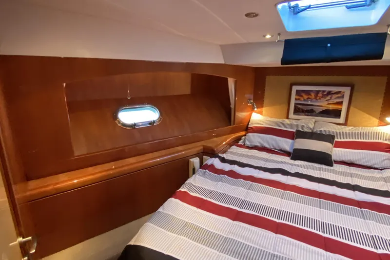 Grey Goose Yacht Photos Pics Luxurious cabin interior of 2000 Compass 55 yacht with striped bedding and wall art.