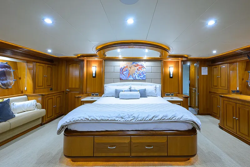 Scott Free Yacht Photos Pics Luxurious bedroom on 2008 President Tri-Deck yacht with elegant wood finishes and ambient lighting.
