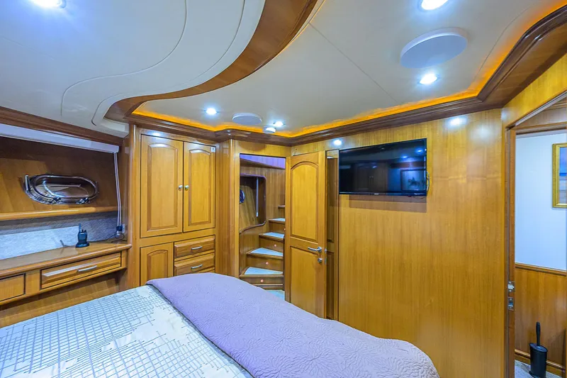 Scott Free Yacht Photos Pics Luxurious 2008 President Tri-Deck yacht bedroom with wood paneling and modern amenities.