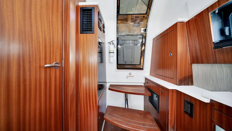 All Jack'd Up Yacht Photos Pics 2023 Pursuit S 428 Sport cabin interior with wood finish and compact seating area.